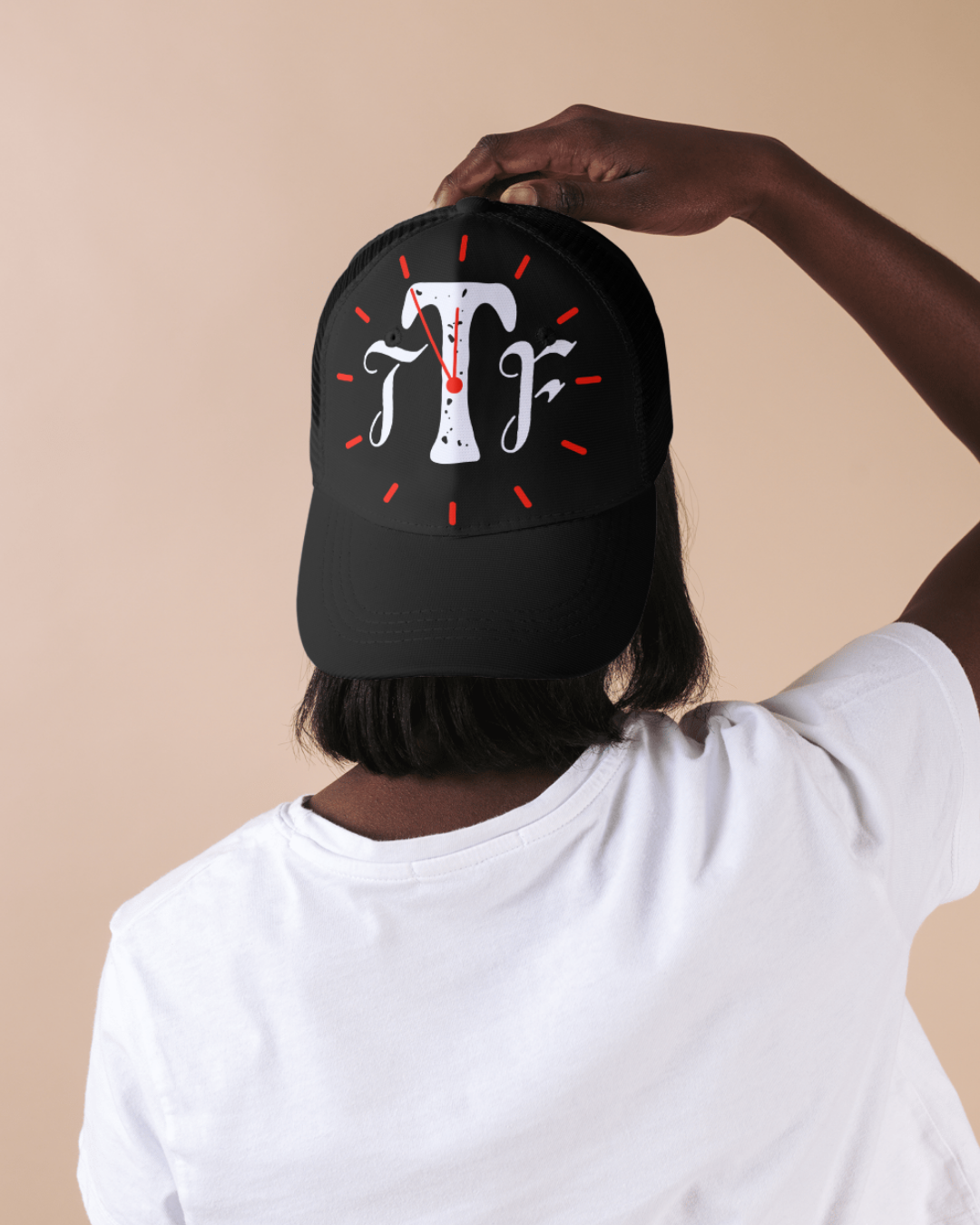 Person wearing a black cap with a logo on a beige background